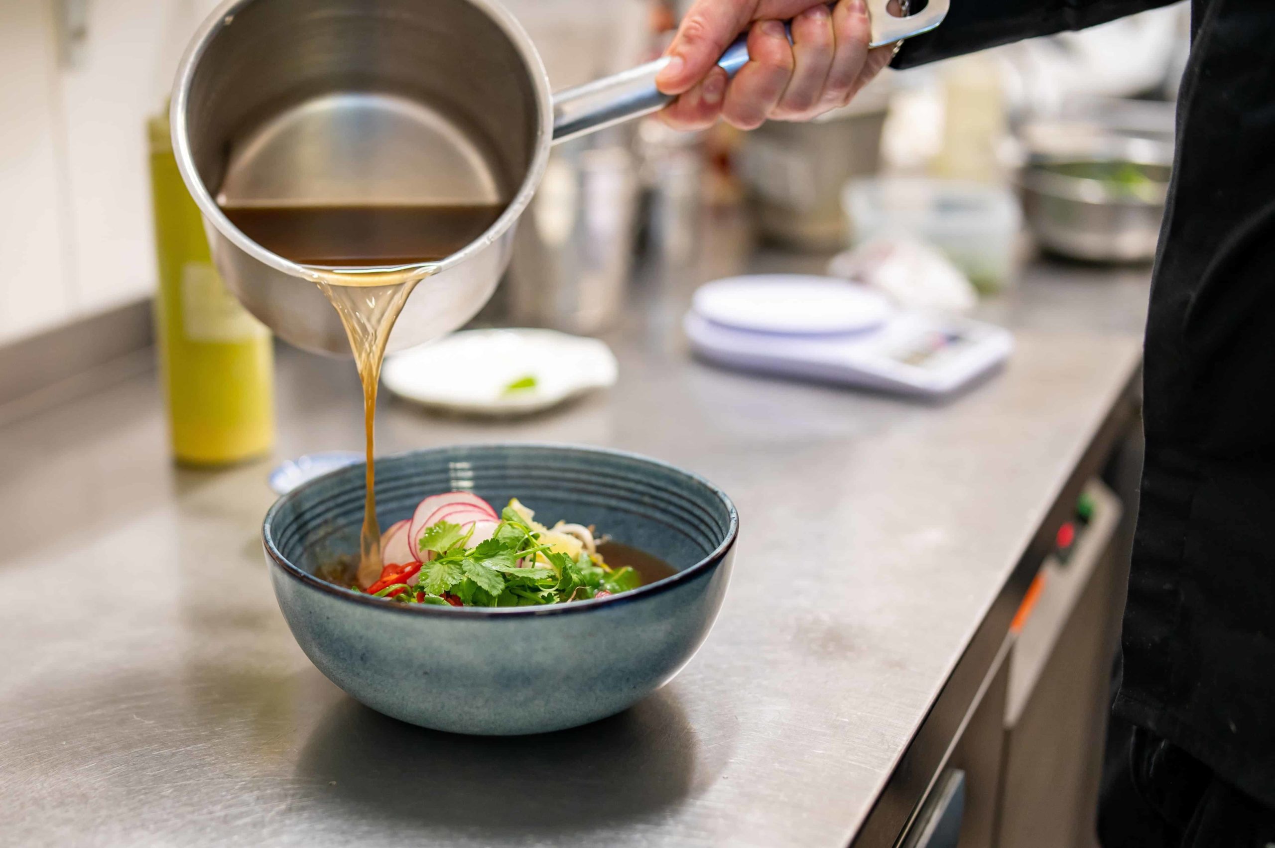 A chef cooking Vietnamese Pho in the kitchen